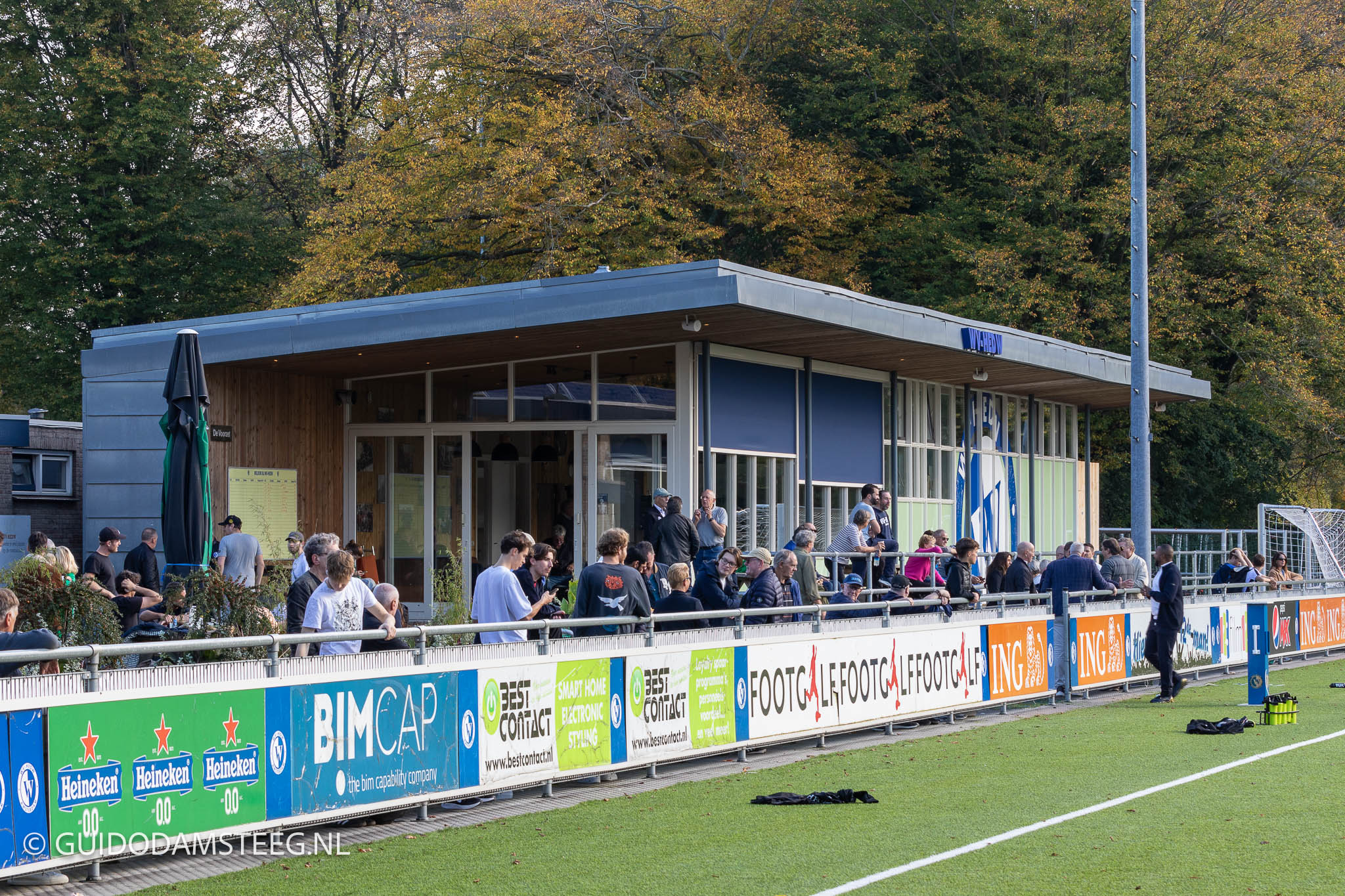 Voetbalclub WV-HEDW met clubhuis en voetbalsupporters.